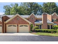 Charming brick townhome with a two-car garage and mature landscaping at 52 Ivy Chase Ne, Atlanta, GA 30342