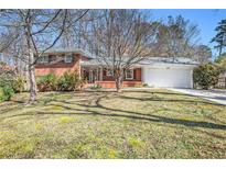 Charming brick home with a manicured lawn and a two-car garage, perfect for suburban living at 2447 Caladium Drive Northeast Ne, Atlanta, GA 30345