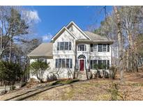 Charming two-story traditional home with stucco facade, black shutters, and a well-manicured front yard at 2012 Trade Winds Dr, Canton, GA 30115