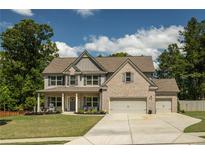 Beautiful two-story home with brick and siding exterior, two-car garage, and a well-manicured front yard at 2106 Sycamore Ln, Loganville, GA 30052