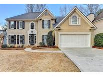 Charming two-story home featuring a manicured lawn, classic shutters, and a spacious two-car garage at 235 Haydens Walk Ct, Johns Creek, GA 30022