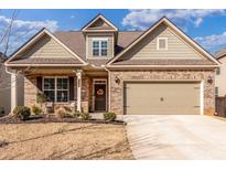 Charming brick home with a well-manicured lawn, inviting front porch, and attached two-car garage at 116 Holly View Ln, Canton, GA 30114