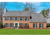 Charming brick home featuring dark shutters, a manicured lawn, and a classic architectural style at 1293 Wynford Colony Sw, Marietta, GA 30064