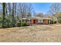 Charming red brick home featuring a well-maintained front yard and a convenient carport at 1269 Lawndale Ct, Decatur, GA 30032