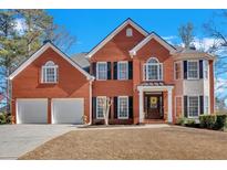 Charming two-story red brick home featuring a well-manicured lawn, and attached two car garage at 577 Alexander Farms Sw Vw, Marietta, GA 30064