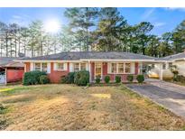 Charming brick home featuring a well-maintained lawn and a convenient carport at 1147 Longshore Dr, Decatur, GA 30032