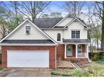 Charming two-story home with a brick facade, attached garage, front porch, and a well-maintained yard at 447 Hemlock Dr, Pine Lake, GA 30083