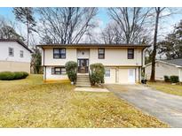 Inviting two-story home featuring neutral siding, brick accents, landscaped front yard, and a double driveway at 2284 Emerald Springs Dr, Decatur, GA 30035