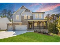 Beautiful two-story home with a brick and gray siding, a front porch with dark wood posts, and a well-manicured lawn at 2460 Hidden Creek Rd, Kennesaw, GA 30152