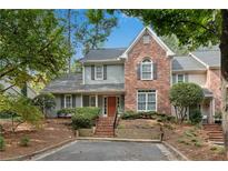 Charming home with brick and gray siding, complemented by lush landscaping and a well-maintained front yard at 146 River Ridge Ln, Roswell, GA 30075