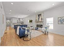 Bright, open living room features a modern fireplace, hardwood floors and stylish furnishings at 3279 Elm St, College Park, GA 30337
