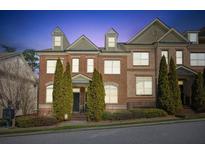 Charming brick townhome featuring manicured landscaping and classic architectural details at 7420 Glisten Ave, Sandy Springs, GA 30328