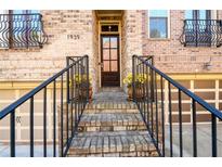 Inviting brick home entrance with black wrought iron railings and planters, leading to a covered porch and front door at 1939 Ridgemont Ln, Decatur, GA 30033