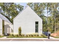 Modern exterior with white horizontal siding, clean lines, and manicured landscaping at 1290 Lupo Loop, Chattahoochee Hills, GA 30268