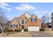 Charming two-story brick home with a well-manicured lawn and attached two-car garage at 1471 Adair Hill Ct, Dacula, GA 30019