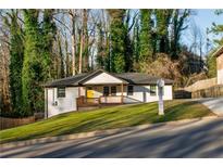 Charming single-story home featuring a yellow front door, front porch, and fresh green landscaping at 2486 Rockcliff Se Rd, Atlanta, GA 30316