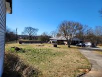 Expansive front yard featuring a pool and a well-maintained lawn surrounding a single-story home and driveway at 46 Mac Johnson Nw Rd, Cartersville, GA 30121