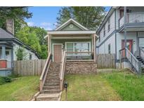Charming home with a stone foundation and a covered front porch, enhanced by a well-maintained lawn at 490 Rockwell Sw St, Atlanta, GA 30310
