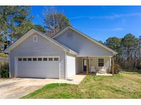 Charming single-story home with attached garage and cozy front porch, perfect for relaxing outdoors at 100 Mountainside Ln, Covington, GA 30016