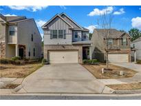 Two-story home showcasing a well-maintained front yard, brick accents, and a two-car garage at 5113 Rapahoe Trl, Atlanta, GA 30349