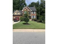 Beautiful two-story brick home with manicured lawn and mature trees providing privacy at 2431 Weatherstone Se Cir, Conyers, GA 30094