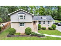 Charming home featuring a brick facade, complemented by lush landscaping and mature trees at 2657 Langland Ne Ct, Atlanta, GA 30345