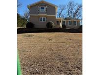 Two-story home featuring gray siding, a brick base, and large front yard space with a small landscaped wall at 2657 Langland Ne Ct, Atlanta, GA 30345