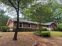 Charming brick home featuring a landscaped front yard and attached garage at 308 Tulipwood Sw Cir, Conyers, GA 30094