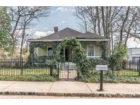 Charming home with beautiful foliage, well-maintained lawn and black fence at 3670 Union Ave, Atlanta, GA 30354