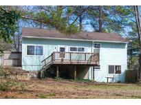 Charming home featuring a cozy wooden deck overlooking the spacious backyard with mature trees and partial fence at 5087 Fairmont Se Rd, Smyrna, GA 30082