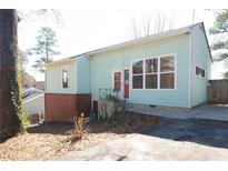 Charming home with a brick foundation, light blue siding, large windows, and a welcoming red door at 5087 Fairmont Se Rd, Smyrna, GA 30082