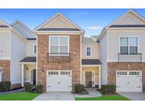 Charming townhome featuring a stone and siding facade, well-manicured lawn, and an attached single-car garage at 2502 Capella Sw Cir, Atlanta, GA 30331