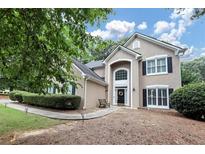 Charming home featuring a two-story entrance, manicured lawn, and inviting walkway to the front door at 6815 Fairgreen Dr, Suwanee, GA 30024