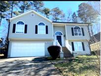 Charming two-story home with a well-manicured lawn, arched windows, and a two-car garage at 2250 Camp Town Way, Lawrenceville, GA 30044
