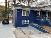 Blue brick home with a concrete driveway and well-maintained front yard at 612 Cedar Nw Ave, Atlanta, GA 30318