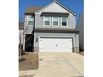 Charming two-story home featuring a gray siding, a two-car garage, and a well-maintained front lawn at 156 Auburn Crossing Dr, Auburn, GA 30011
