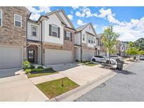 Charming brick and siding townhomes with attached garages and well-maintained landscaping create inviting curb appeal at 1409 Ben Park Way, Grayson, GA 30017