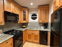 Bright kitchen features wood cabinetry, granite countertops, and modern appliances at 5400 Roswell Rd # K1, Atlanta, GA 30342