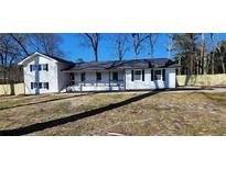 Charming white brick home with a welcoming front porch and freshly landscaped yard at 1390 White Oak St Se, Conyers, GA 30013