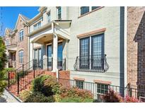 Charming townhome with brick accents, black railings, and colorful landscaping at 327 Alderwood Ln, Atlanta, GA 30328