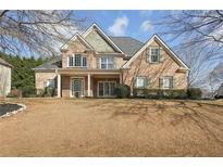 Charming brick two-story home with inviting front porch and well-maintained landscaping at 448 Cape Ivey Dr, Dacula, GA 30019