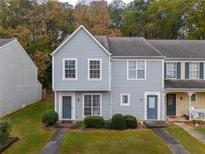 Charming two-story townhouse with blue siding, manicured lawn, and inviting front entrance at 6711 Witherington Ct, Norcross, GA 30093