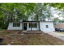 Charming single-story home featuring a welcoming front porch, freshly painted white exterior, and well-maintained landscaping at 1995 Northerly Way, Stone Mountain, GA 30088