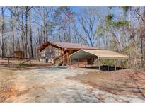 Charming cabin-style home with metal roof, wooden siding and a convenient carport at 2762 Zingara Ne Rd, Conyers, GA 30012