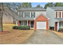 Charming townhome featuring brick accents, an attached garage, and a well-maintained front yard at 4607 Ravenwood Loop, Union City, GA 30291