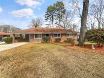 Charming single-story home featuring a brick facade, covered carport, and well-maintained landscaping at 1742 Mural Dr, Morrow, GA 30260