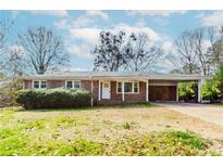 Charming one-story brick home with a covered carport and well-maintained landscaping in a suburban neighborhood at 3951 Lindley Dr, Powder Springs, GA 30127