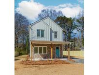 Charming two-story home with a stone facade, covered porch and a bright turquoise front door at 898 Center Hill Nw Ave, Atlanta, GA 30318