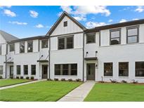 Charming townhome featuring a white brick facade, dark trim, and a well-maintained lawn at 1324 Parc Bench Rd, Atlanta, GA 30316