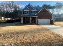 Charming two-story home with brick and siding, a well-manicured lawn, and attached garage at 171 Gorham Gates Dr, Hiram, GA 30141